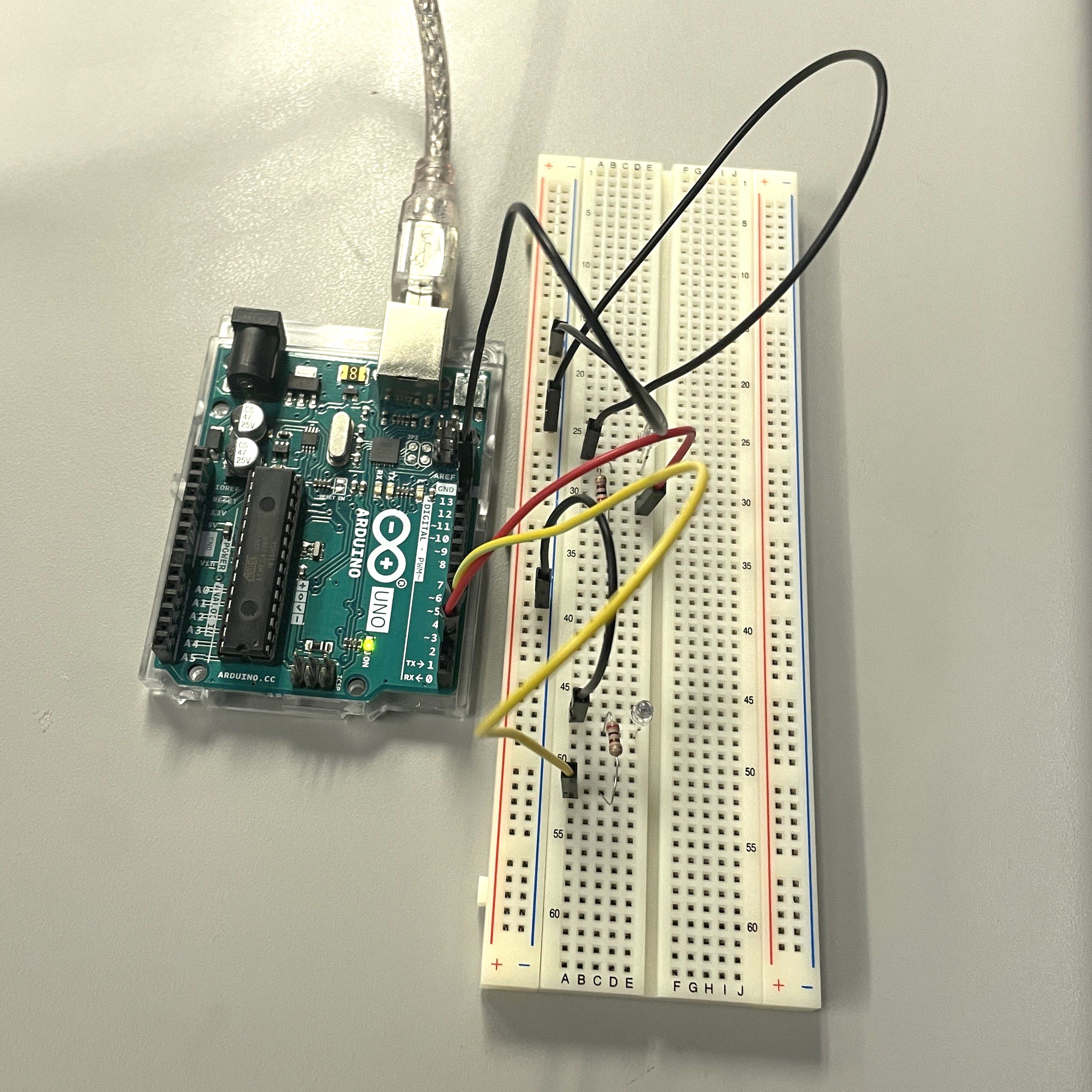 Arduino Uno connected to the breadboard with wires, two LEDs, and a resistor to show the hardware setup for the blink circuit.